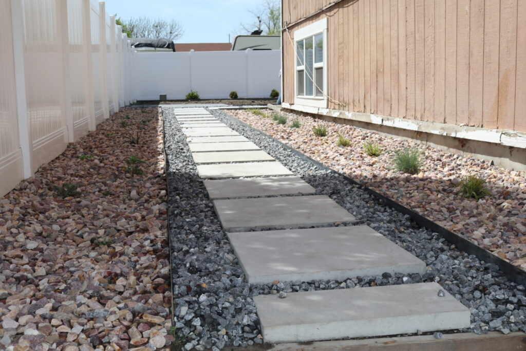 Stone pathway beside wooden house in backyard