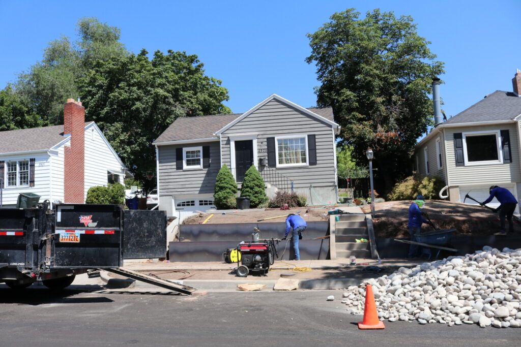 Construction workers landscaping in front of a house.