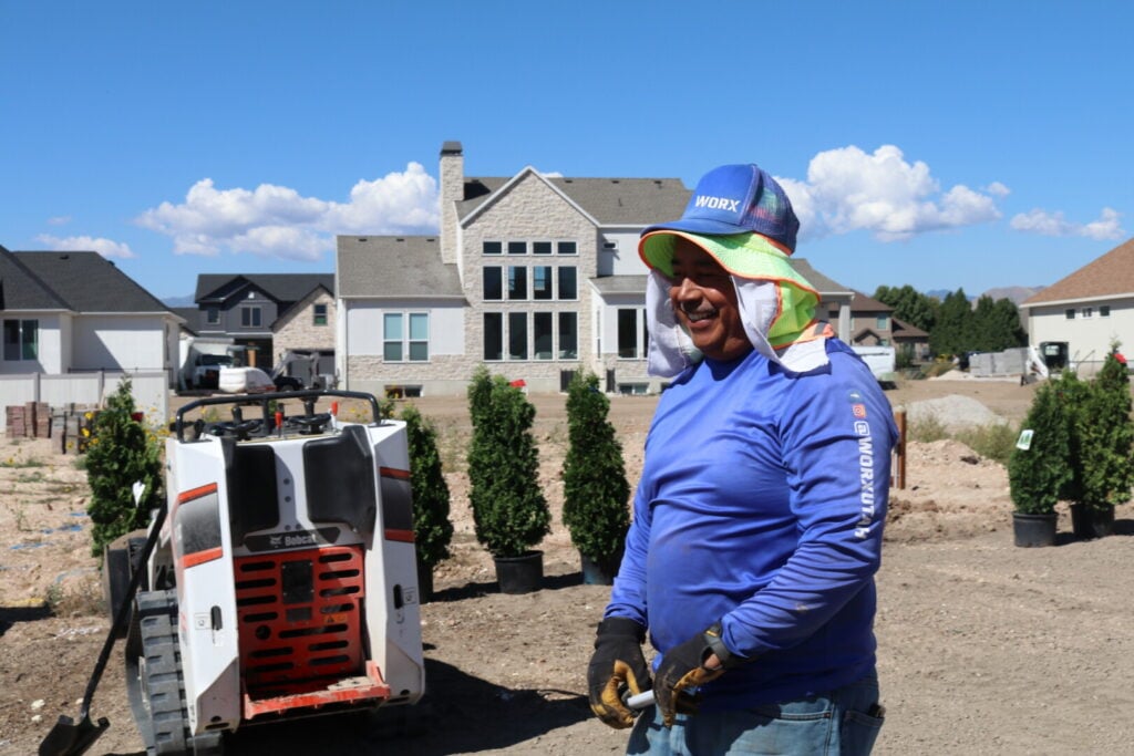 Tree installation with smiling worx crew member