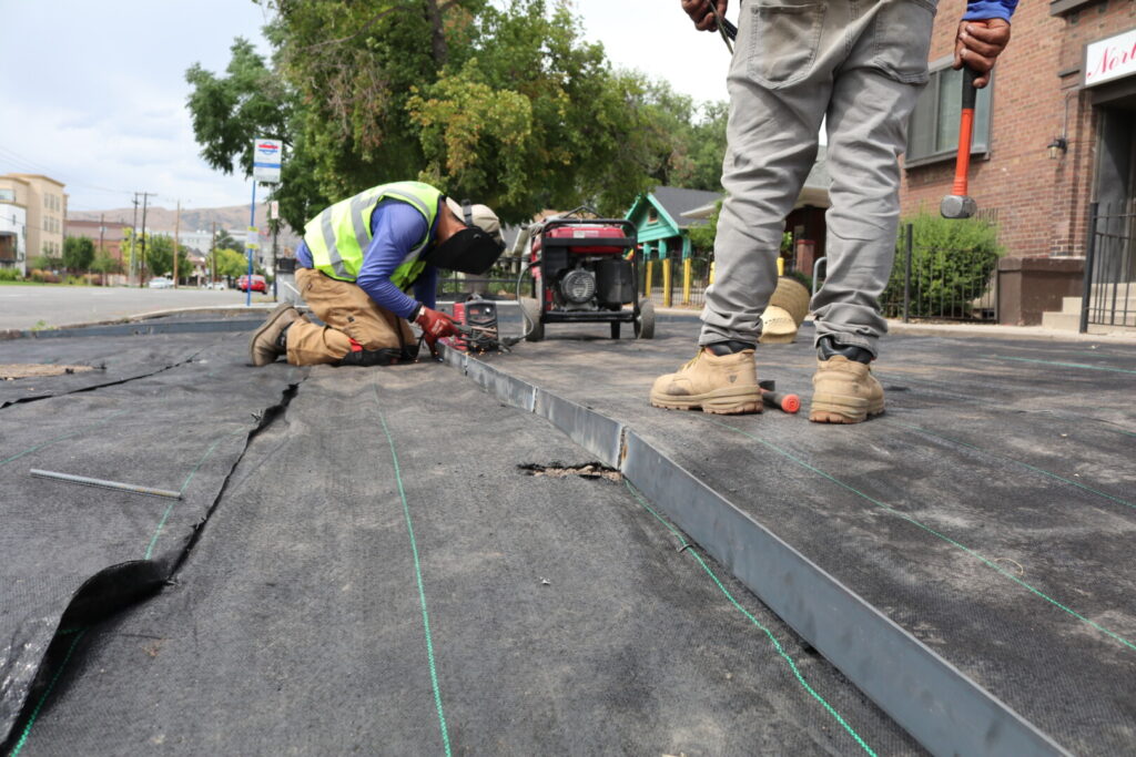 Construction workers welding metal frame on site