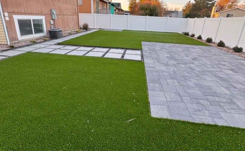 Backyard with artificial grass and paving stones