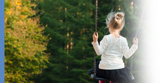 Child on swing in forest
